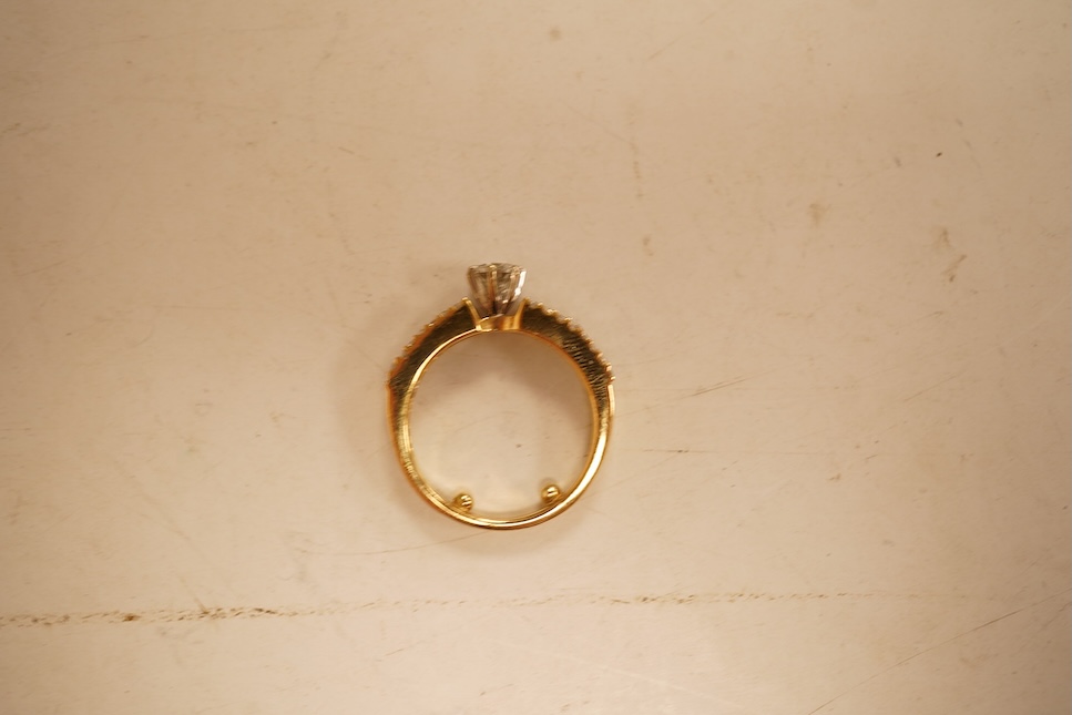 A modern yellow metal and single stone diamond set ring, with baguette and round cut diamond cluster set shoulders, total diamond weight approx. 0.50ct, size J/K (sizing spheres), gross weight 4.6 grams.